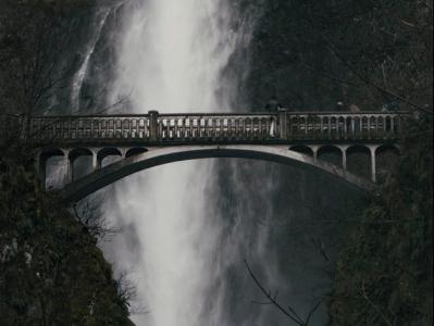 bridge with waterfall behind it