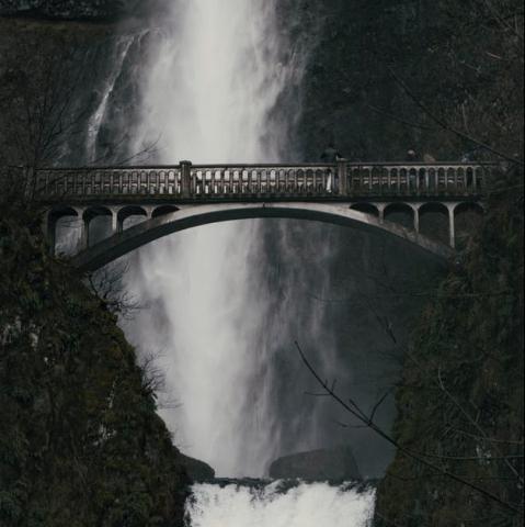 bridge with waterfall behind it